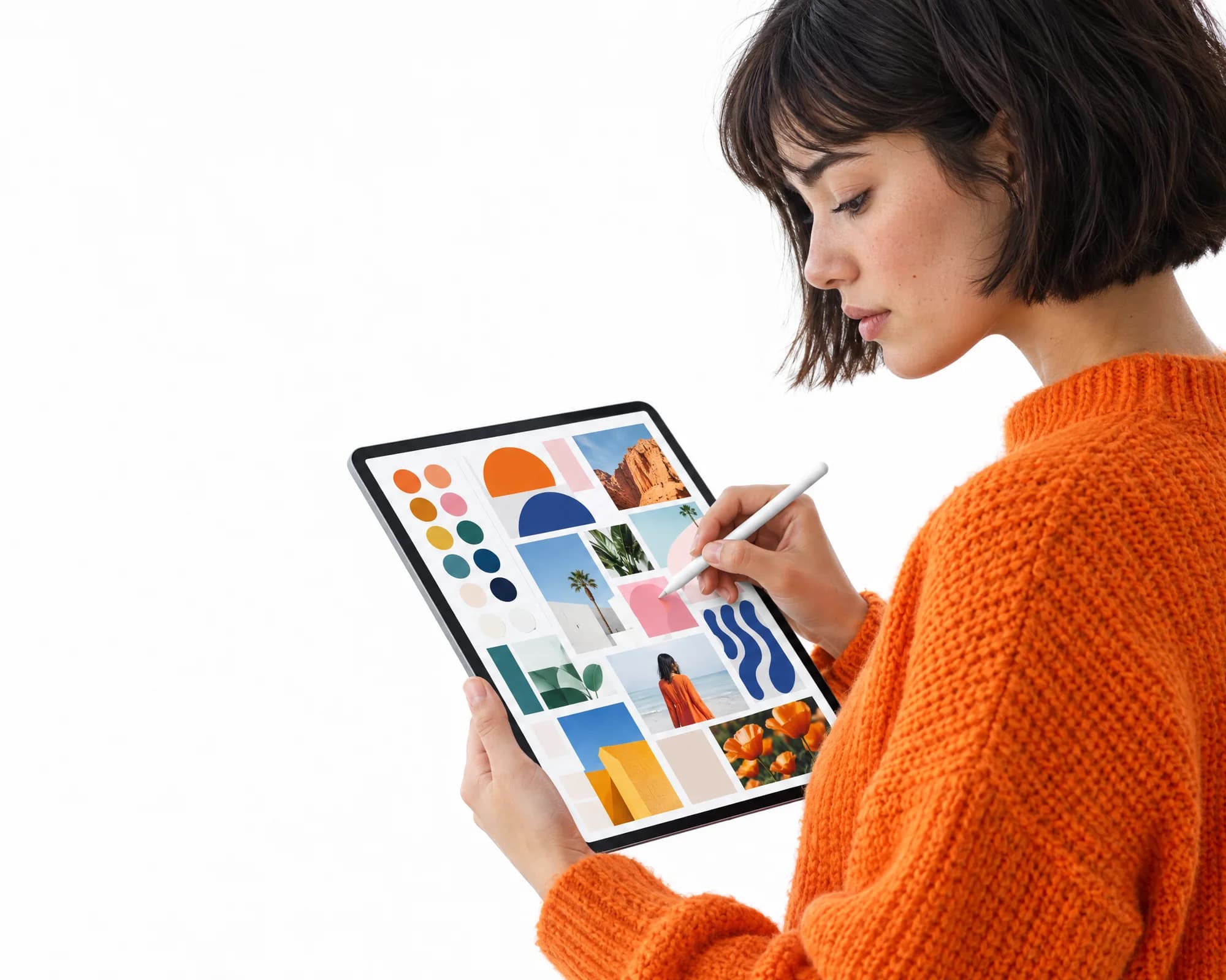 Une femme en pull orange dessine une planche de tendances sur une tablette